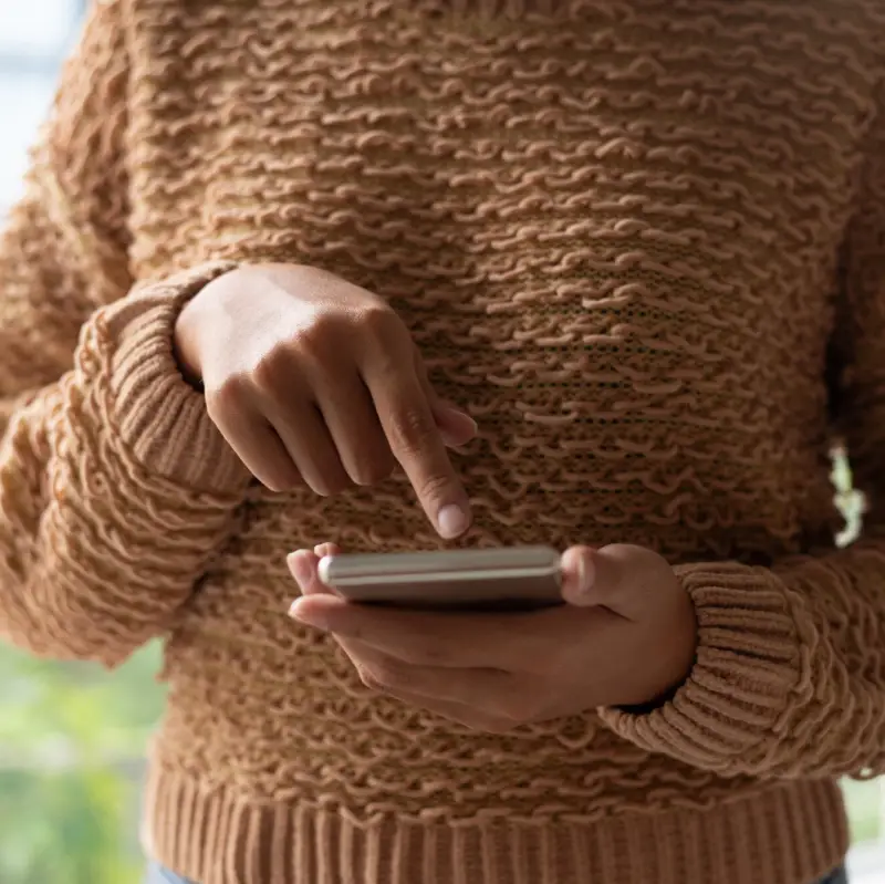 Close-up of woman using smartphone and scrolling web page